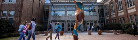 Spring day in front of the Wall Building with Shonibare sculpture and students in the foreground