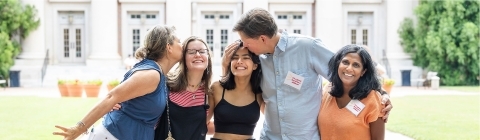 Parents and their students embracing outside and smiling