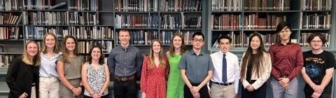 A group of students in front of a bookcase