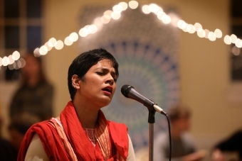 Singer at Diwali sings into microphone with eyes closed