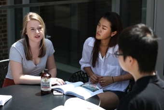 Students sit around table and have a discussion