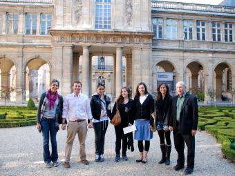 Group of six students and their professor stand in front of Musee Carnavalet in Paris
