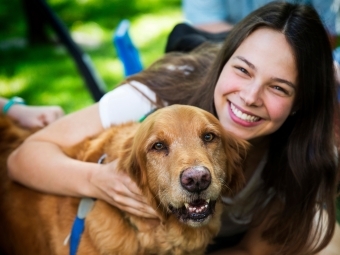 Student hugs light brown dog