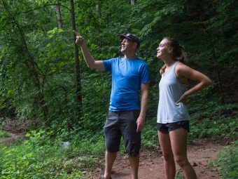 Prof. Brad Johnson and student work in the field as he points out something above them