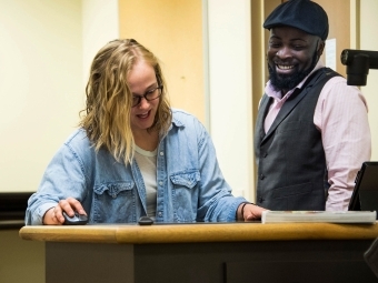 Prof. Ewoodzie and student prepare a presentation by the instructor's computer and projector