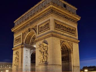 Arc de Triomphe at night with lights from cars as lines