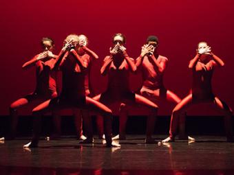 Group of students on stage pose together during a dance performance