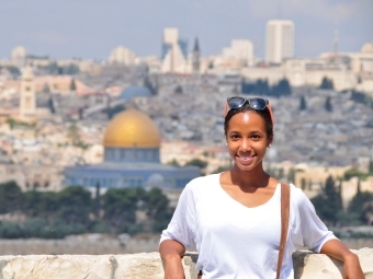 Student stands in front of Amman skyline in Jordan.