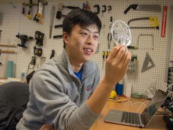 Student admires 3D printed snowflake created in Studio M