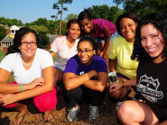 Students take a break from tending to the community garden to gather for a photo