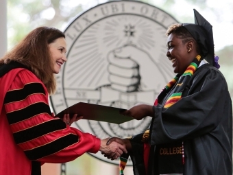 President Quillen and student shake hands at commencement