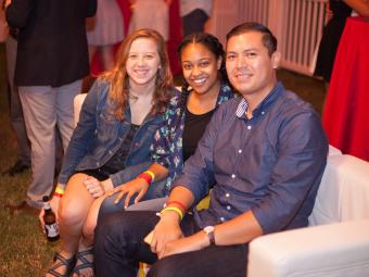 Three alumni sit together at a homecoming event