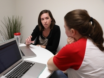 Career adviser works with student on laptop