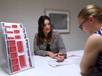 Student consults with career adviser while they both look at career planning paperwork together