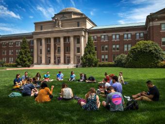 Students sit in a circle on the lawn of Chambers
