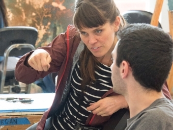 Prof. St. Claire consults with student while demonstrating a painting technique