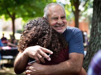 Family member hugs a student while saying goodbye at the Orientation Farewell Picnic on Chambers Lawn