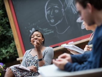 Student sits in class in outdoor classroom and laughs