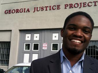 Student fellow stands in front of Georgia Justice Project building