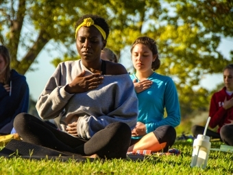 Group of students meditate outdoors