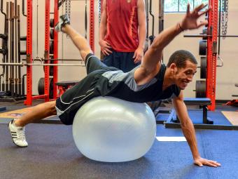 Student works out on an exercise ball in the Doe Weight Room