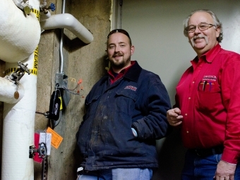 Physical plant employees adjusting equipment