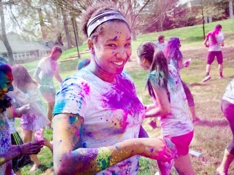 Student is covered in colorful powders during Holi celebrations