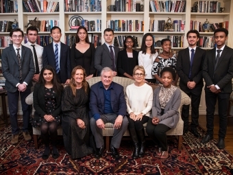 Alvarez family poses with students in front of bookshelves