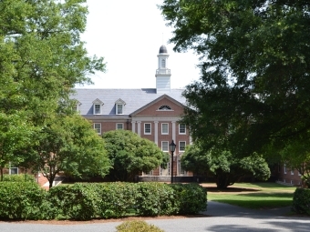 Belk Residence Hall seen through trees and bushes