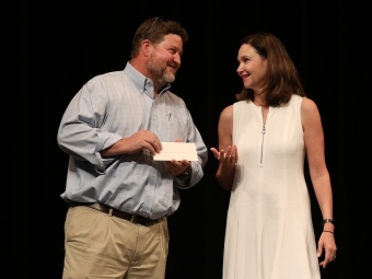 David Holthouser receives envelope from Carol Quillen