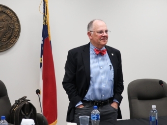 Bob Cordle stands in front of NC flag