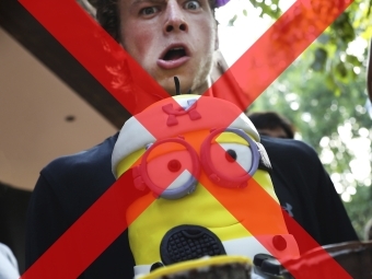 Student holds a Minion cake while making a funny expression but the image is covered by a red x