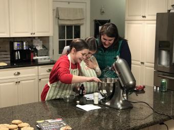 Mom and two daughters work with a mixer