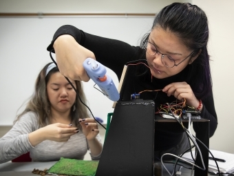 Physics Lab With Three Students Building a house for Tiny Town