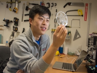 Student holds up 3d printed snowflake