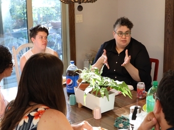 Melissa Gonzalez and students speaking at a table