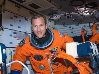 Tom Marshburn in space on ship with orange space suit
