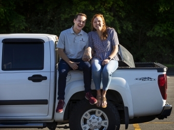 Two friends sitting on trunk of truck 