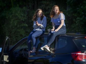 Two friends on top of car 