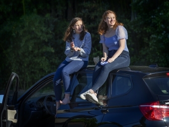 Two friends on top of car