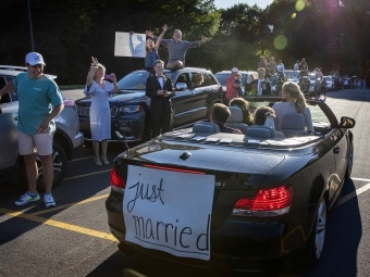 Caroline and Tyler back of car with 'just married' sign 