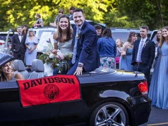 Caroline and Tyler smiling with Davidson flag 