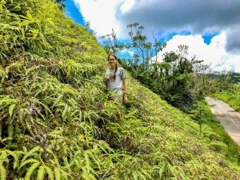 Lydia Soifer stands on a hill covered in vegetation
