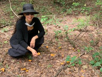 Prof. Courtney Lewis kneeling with chanterelles