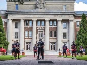 Social Justice Event - football players and campus police officer in front of Chambers