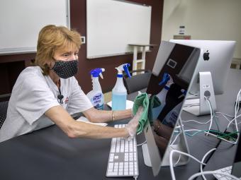 Physical Plant Worker Disinfects Computer