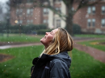 Student smiles as snowflakes fall on her face