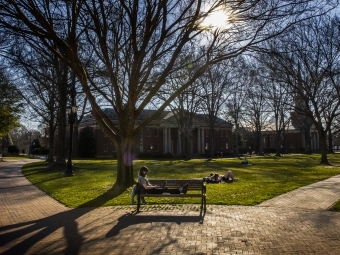 student on bench in front of Chambers lawn