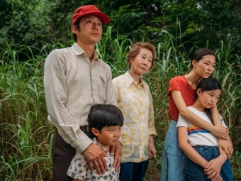 Family embraces in front of greenery