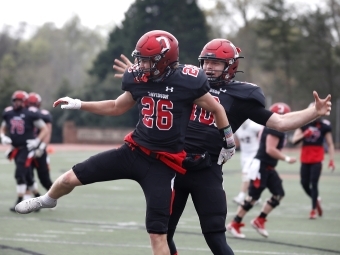 Two Davidson football players jump in celebration